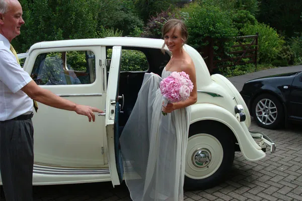 Bride traveling in style in Vintage Triumph wedding car Bride traveling in style in Vintage Triumph wedding car
